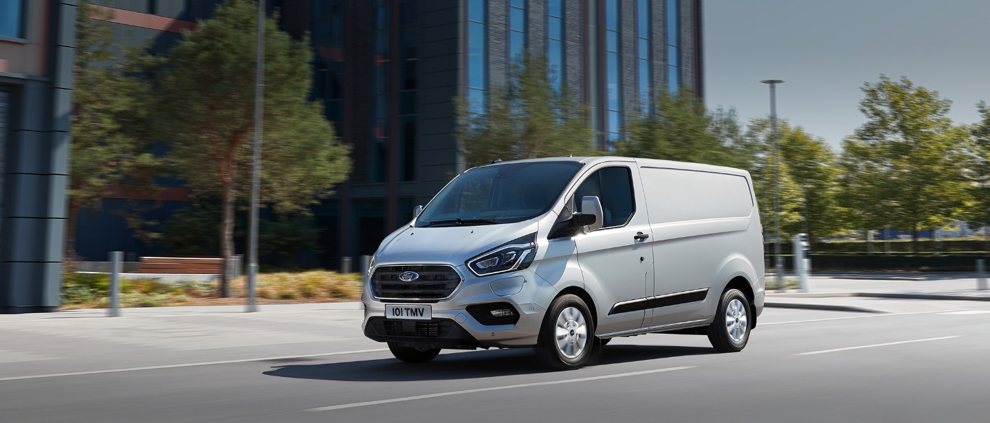 New Orange Ford Transit Custom making deliverySilver New Ford Transit Custom PHEV driving on city road