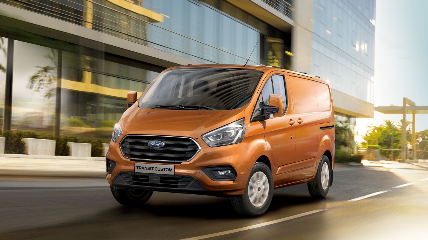 Vue latérale du Ford Transit Custom orange sur en ville. 