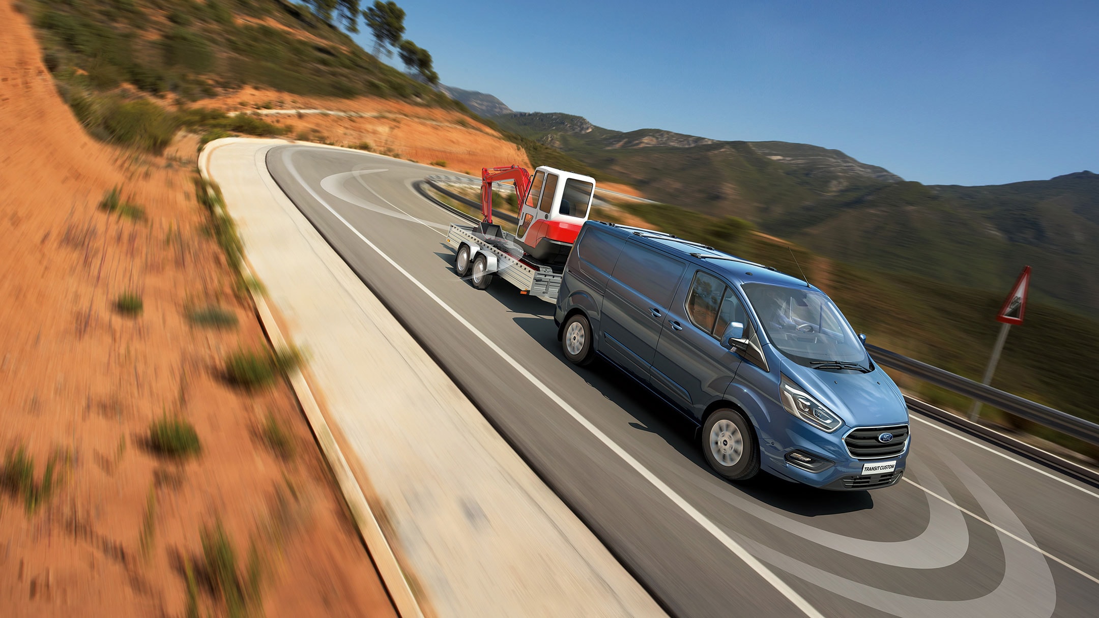 Un Ford Transit Custom bleu sur route. 