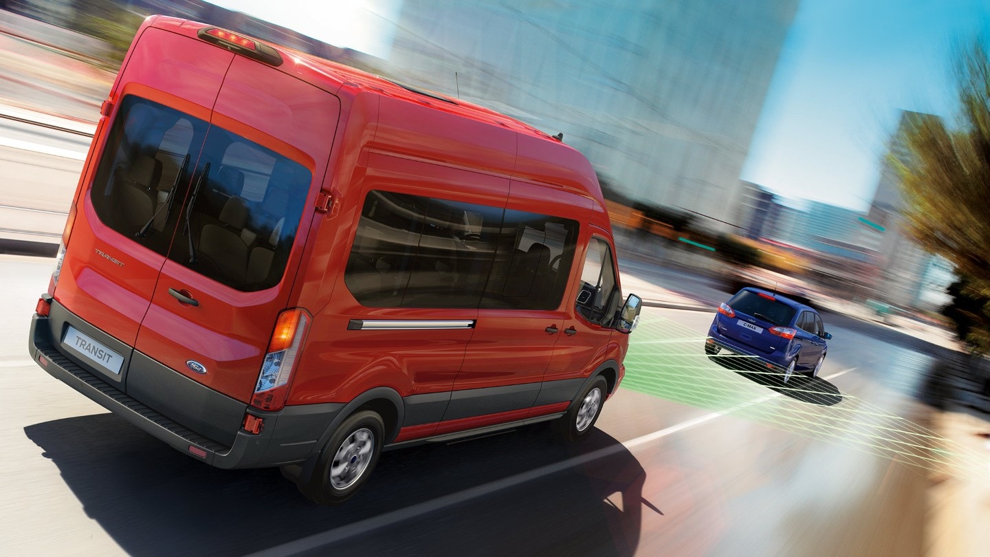 Vue arrière du Ford Transit Minicar sur la route, à proximité d’un véhicule