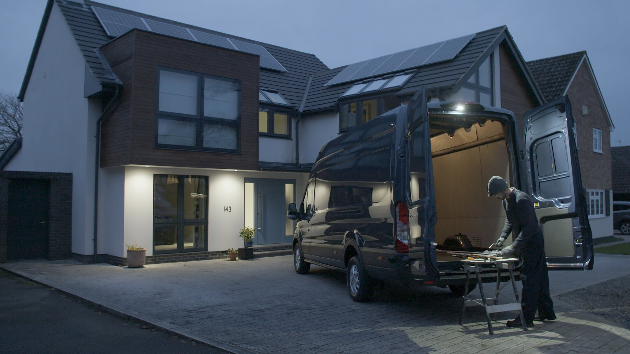 Le Ford Transit garé devant une maison.