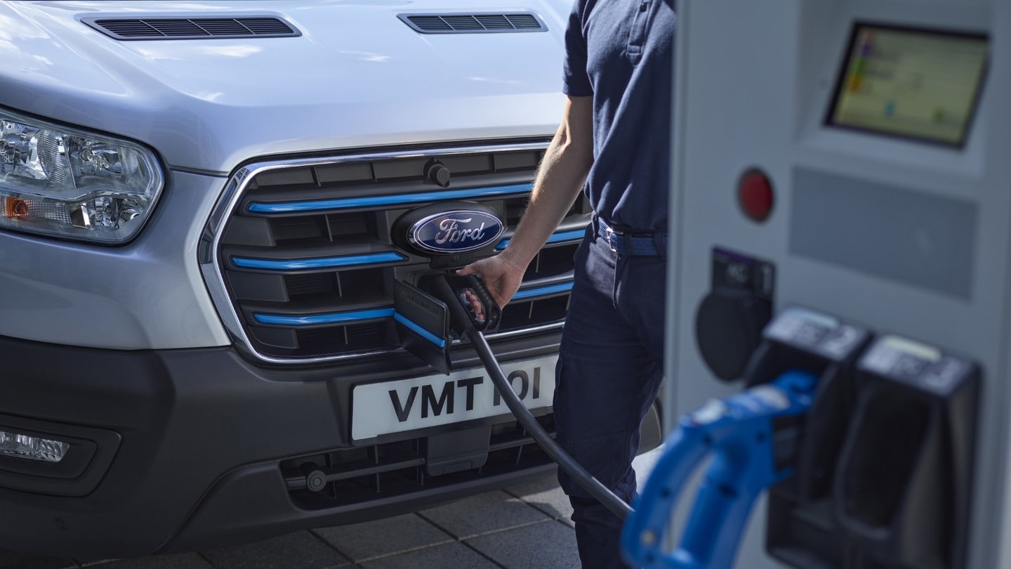 Un Ford E-Transit à une borne de recharge publique. 