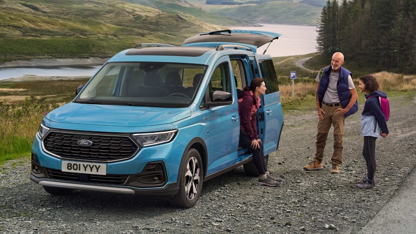 Trois personnes discutant autour du Ford Tourneo Connect.