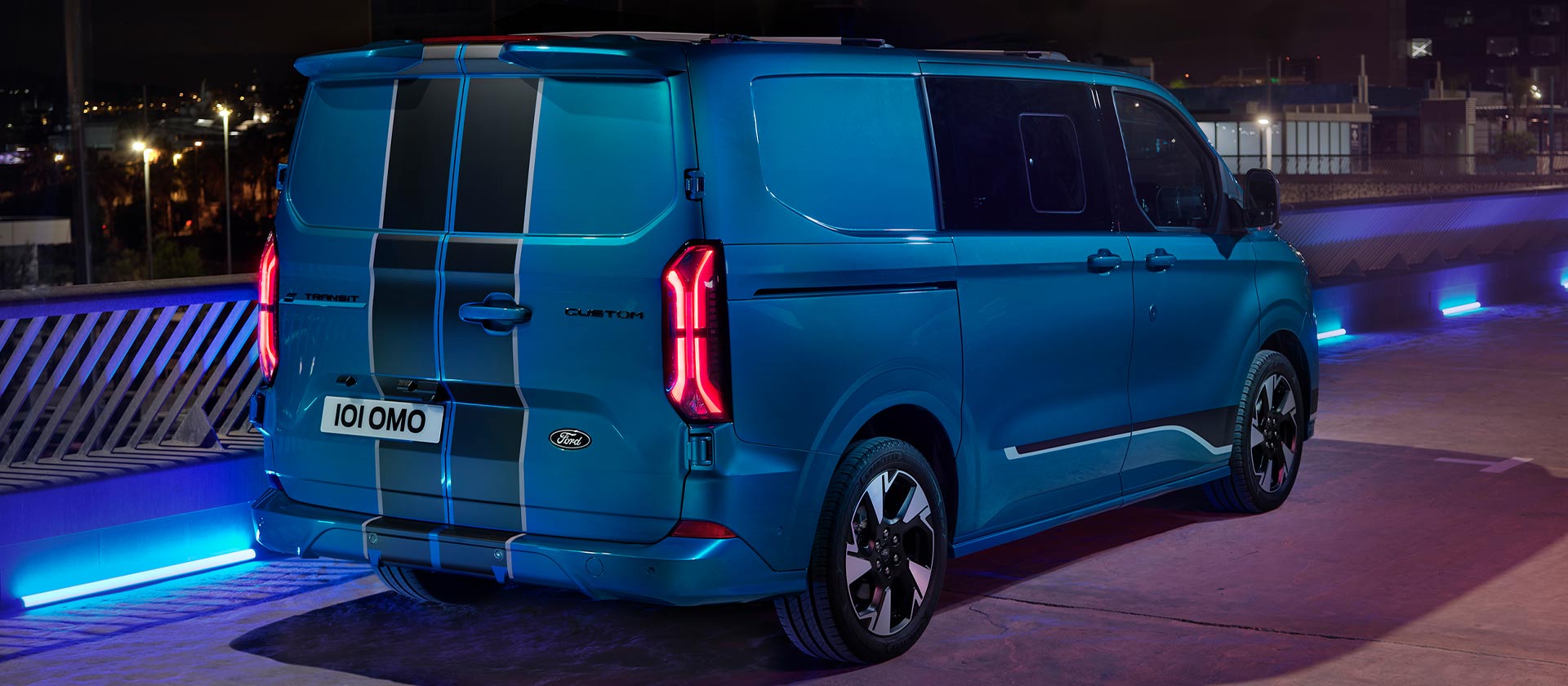 Vue arrière d’un fourgon électrique Ford E-Transit Custom Sport double cabine bleu.