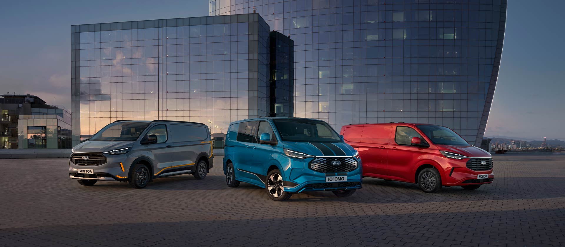 Three Ford Transit Custom Sport vans in grey, blue, and red parked.
