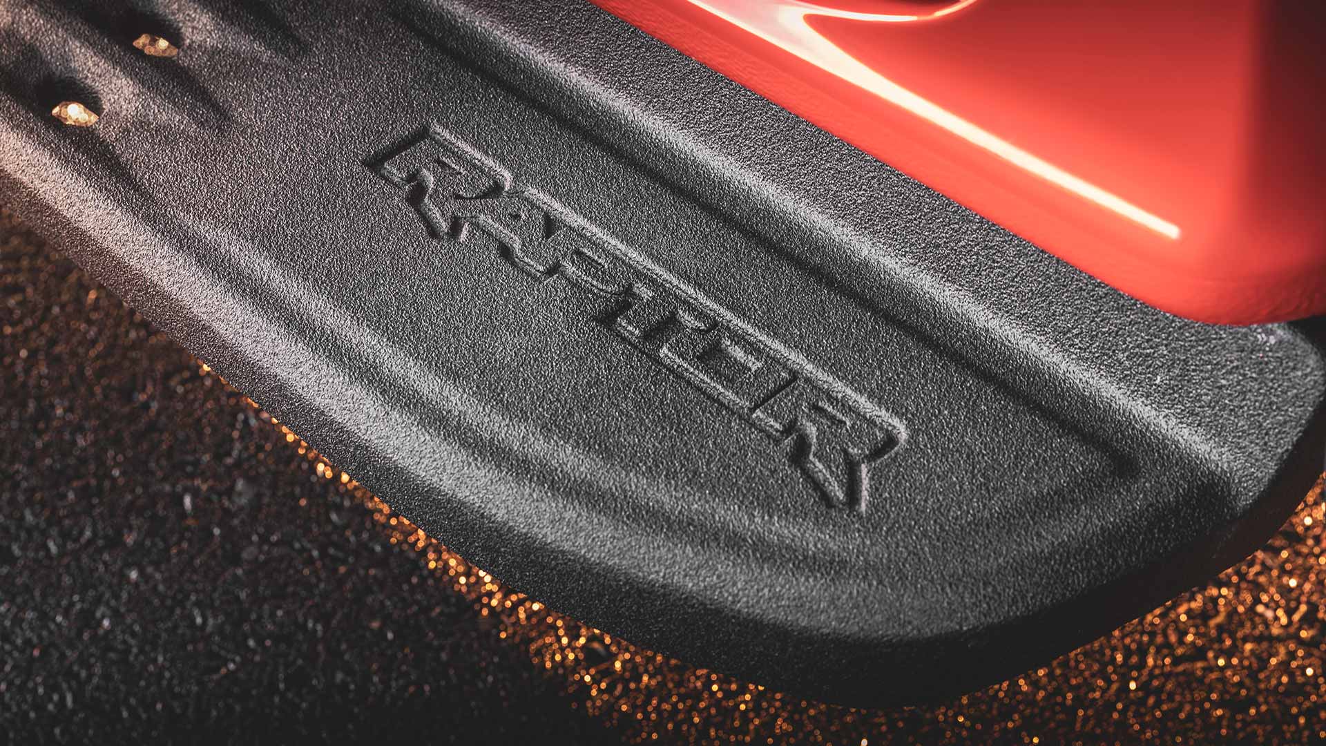Logo Raptor en relief sur la marche latérale noire d’un Ford Ranger Raptor.