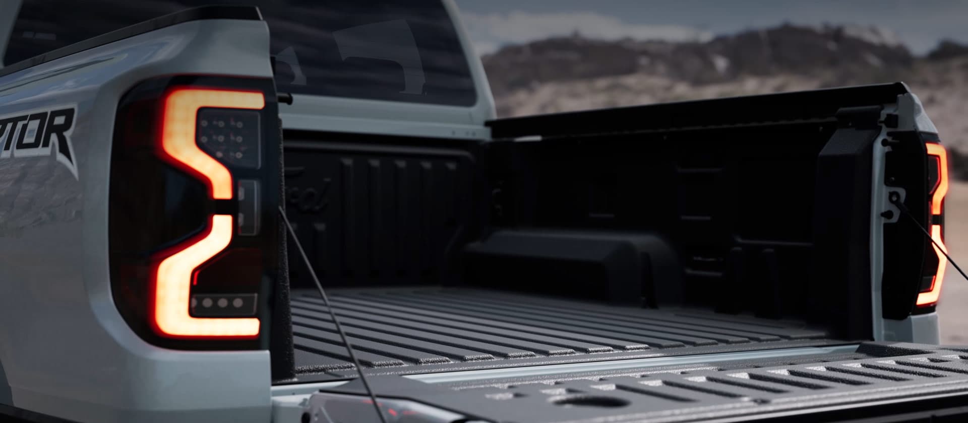 Plateforme d’un Ford Ranger Raptor argenté avec hayon ouvert.