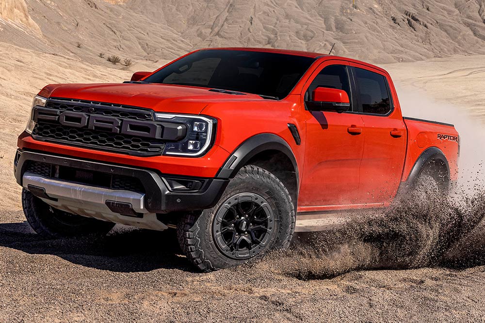 Ford Ranger Raptor Code Orange conduisant dans la saleté.