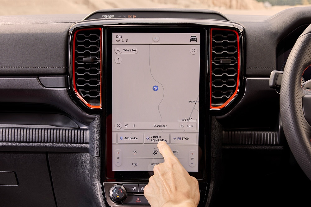 Une personne sélectionnant des options sur l’écran de navigation du Ford Ranger Raptor.