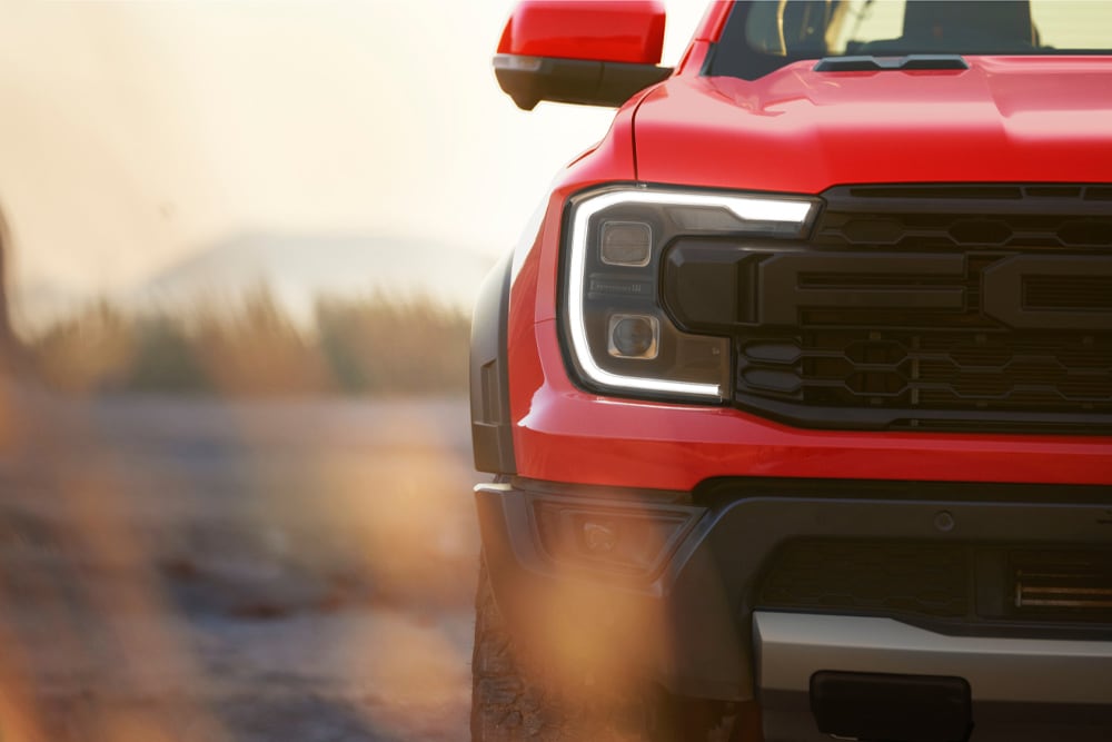 Gros plan sur la calandre d’un Ford Ranger Raptor rouge.