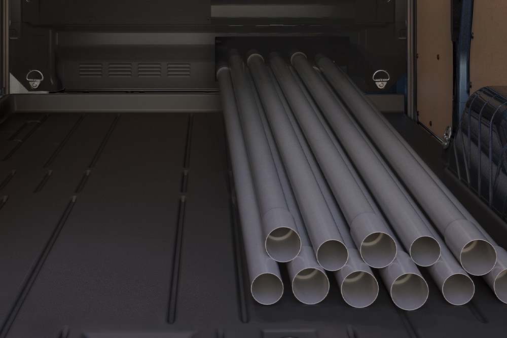 Des tubes chargés à l'intérieur d'un fourgon Ford Transit Custom.