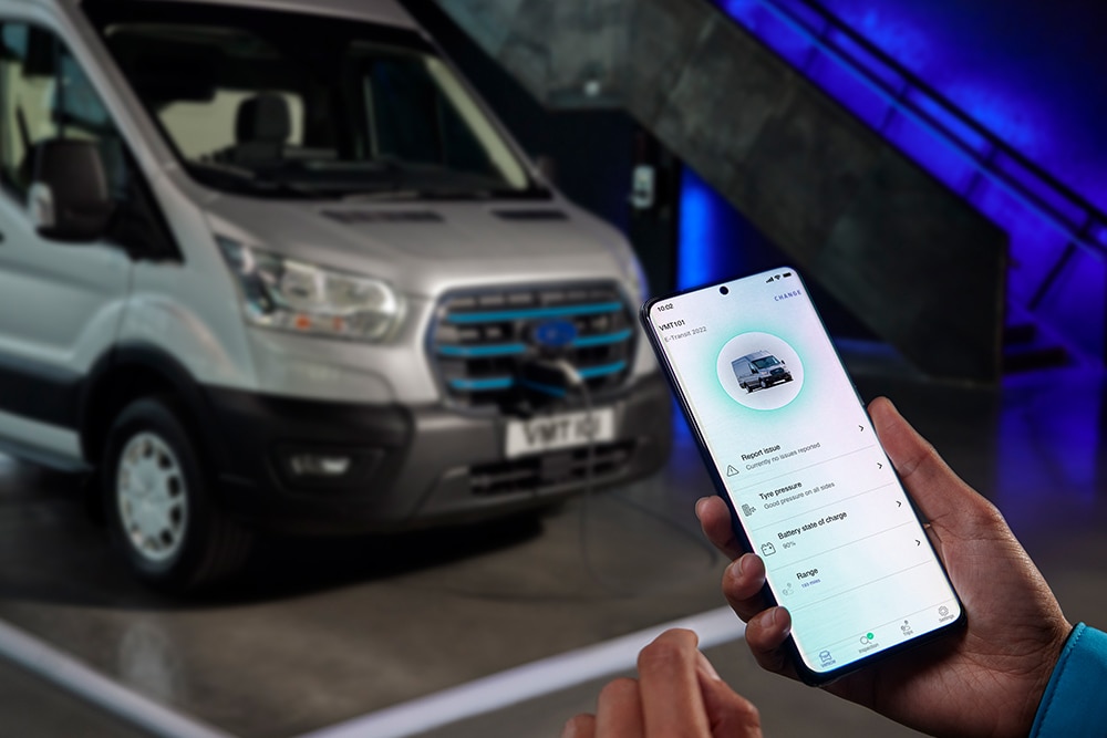 Person holding a mobile phone displaying Ford Pro vehicle data.
