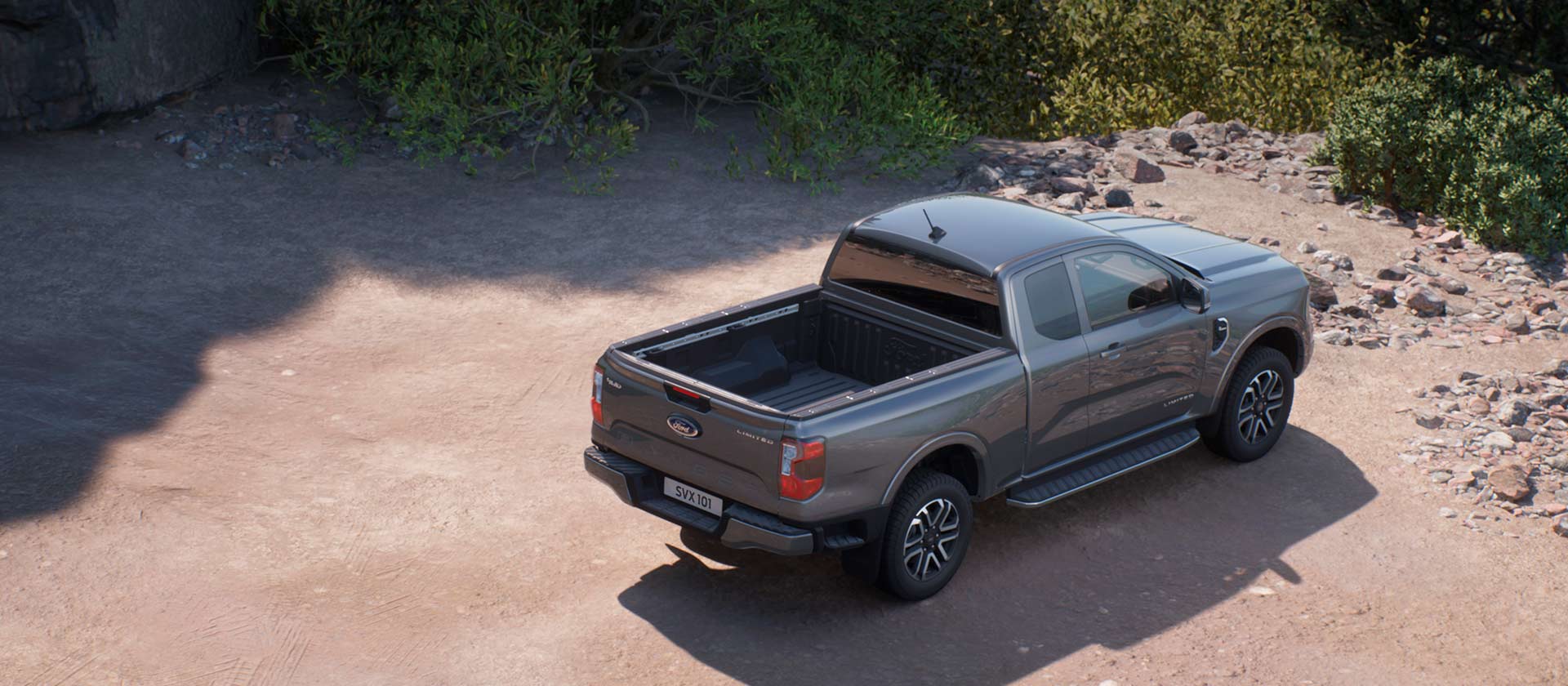 Ford Ranger Super Cab gris est garé sur un chemin de terre.