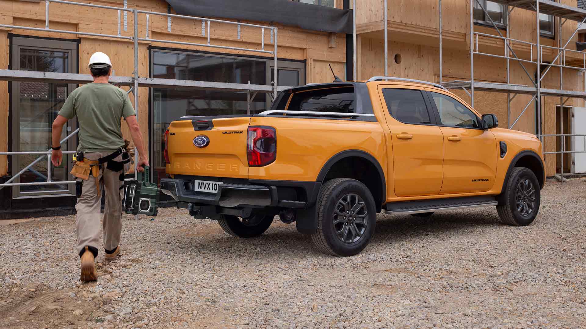 Vue arrière trois quarts du Ford Ranger Wildtrak Double Cabine jaune sur un chantier de construction.