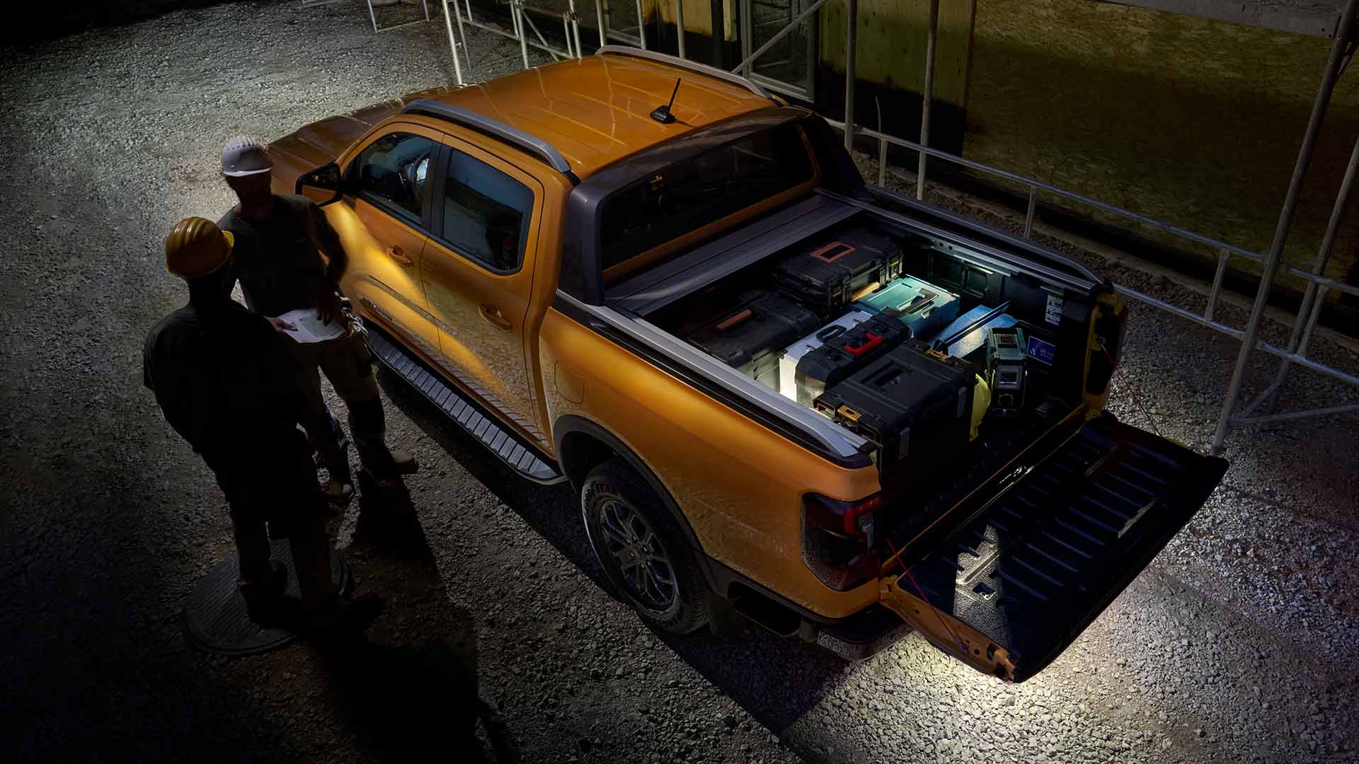 Vue aérienne du Ford Ranger Wildtrak jaune de nuit, avec l’éclairage de zone.