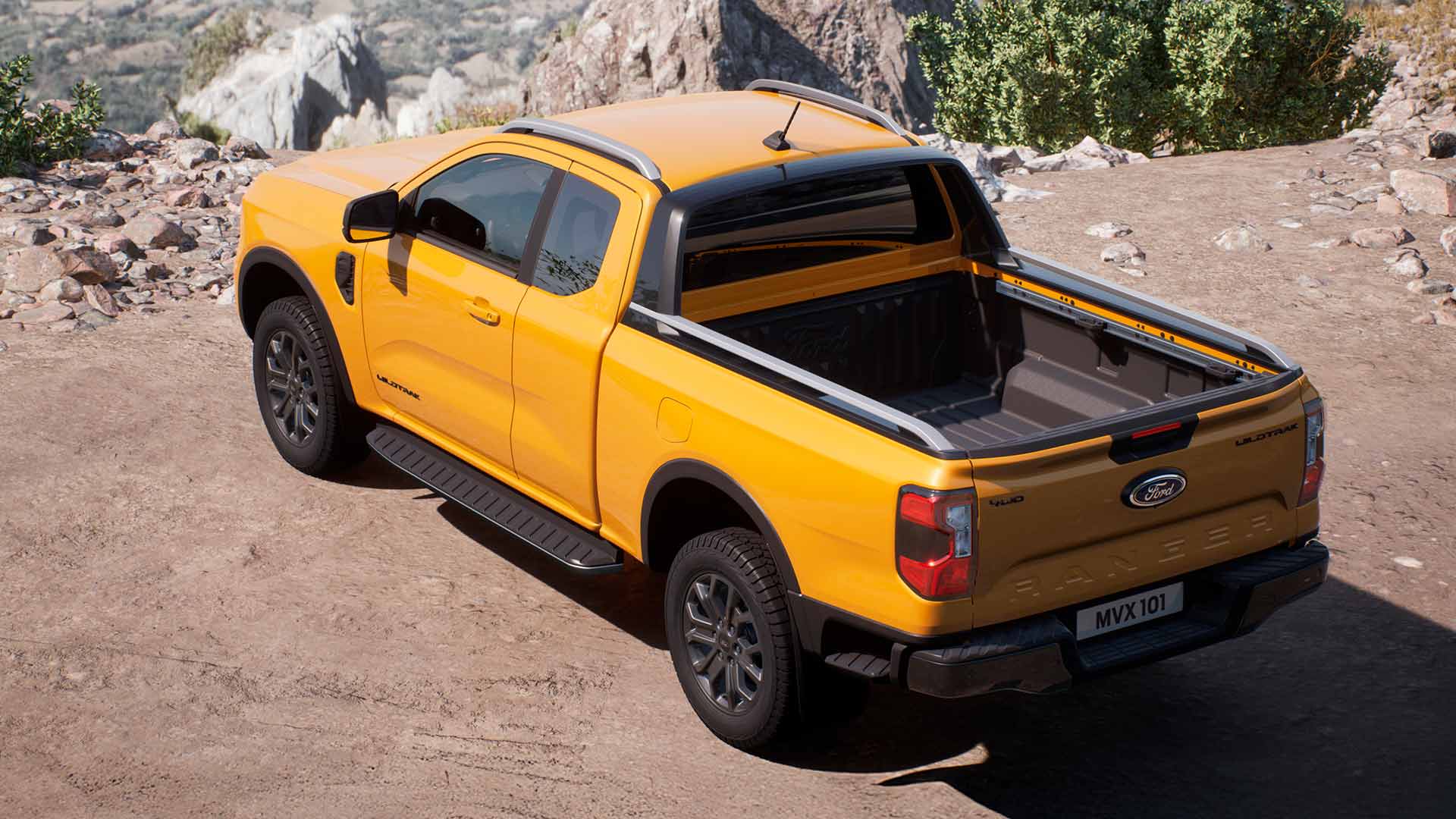 Ford Ranger Wildtrak Super Cab jaune garé sur une surface sablonneuse.