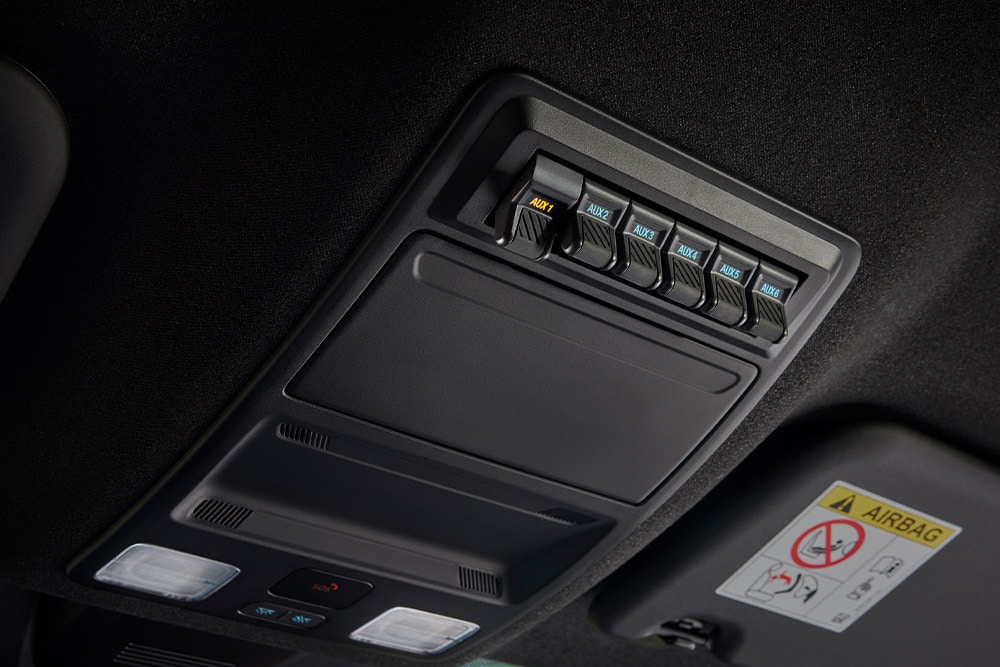 Gros plan sur des mains qui branchent des câbles à la prise électrique du plateau de chargement du Ford Ranger.