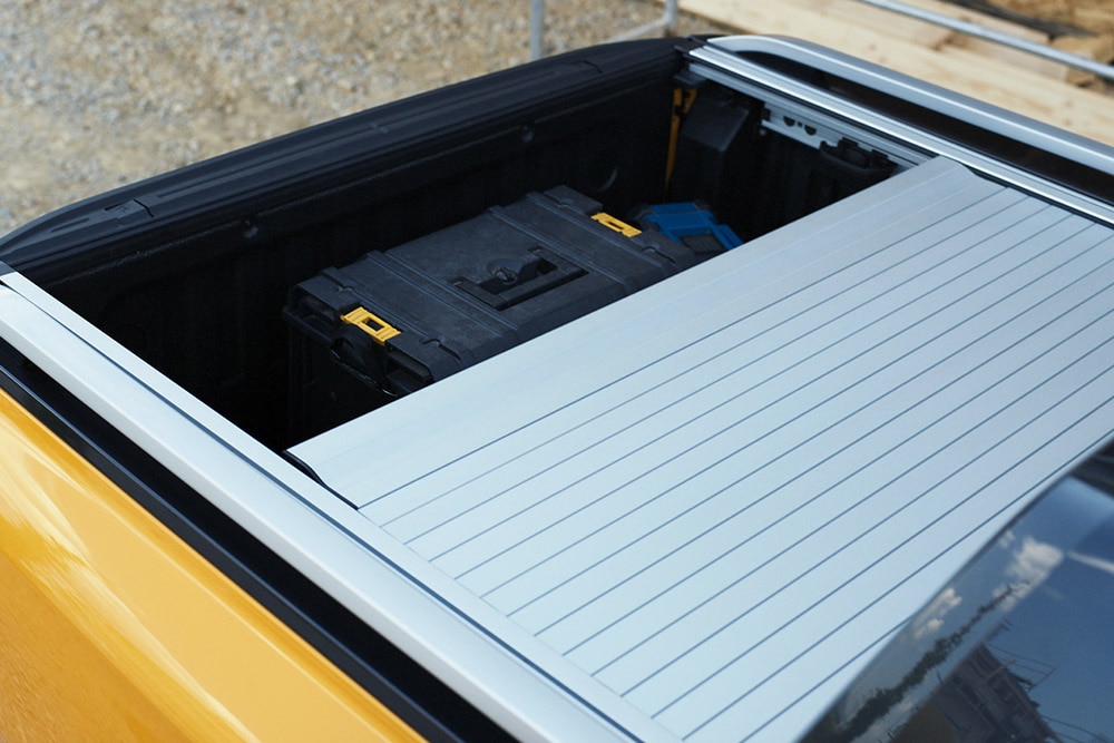 Travailleur montant sur le marchepied arrière intégré du Ford Ranger.