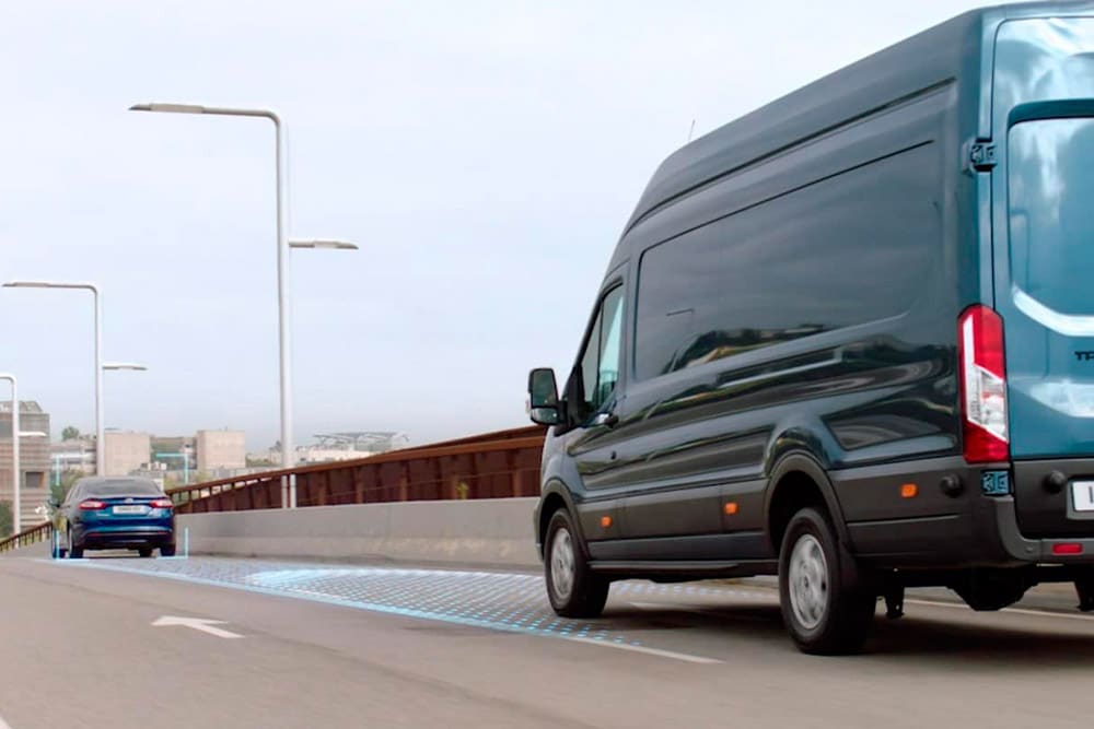 Fourgon Ford Transit bleu avec des lignes bleues sur la chaussée indiquant l’utilisation du système adas avancé.