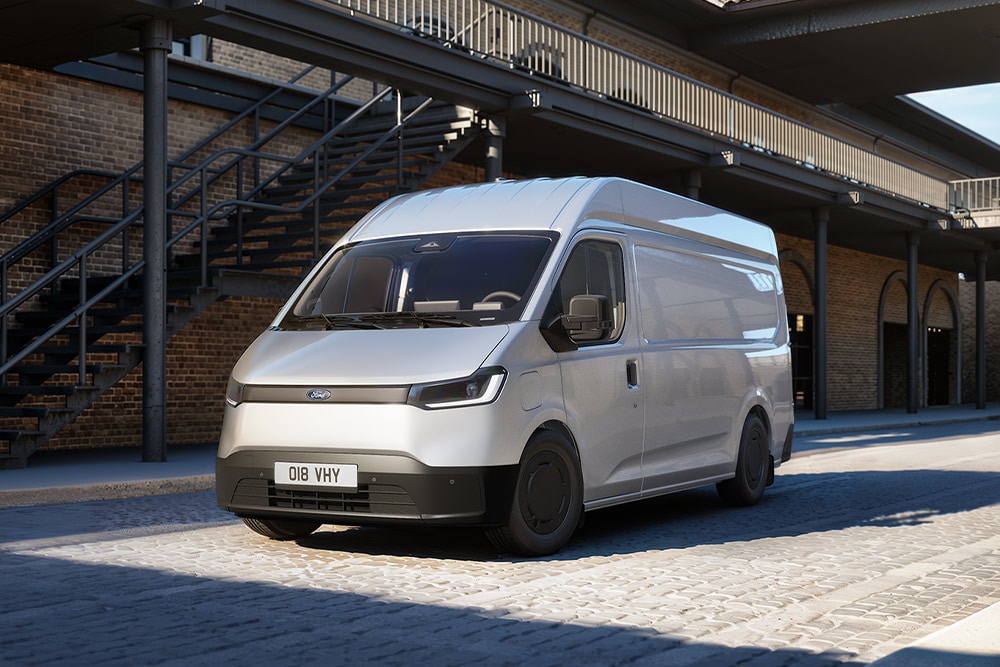 Fourgon Ford Transit City® L2H2 blanc stationné devant un bâtiment en briques.