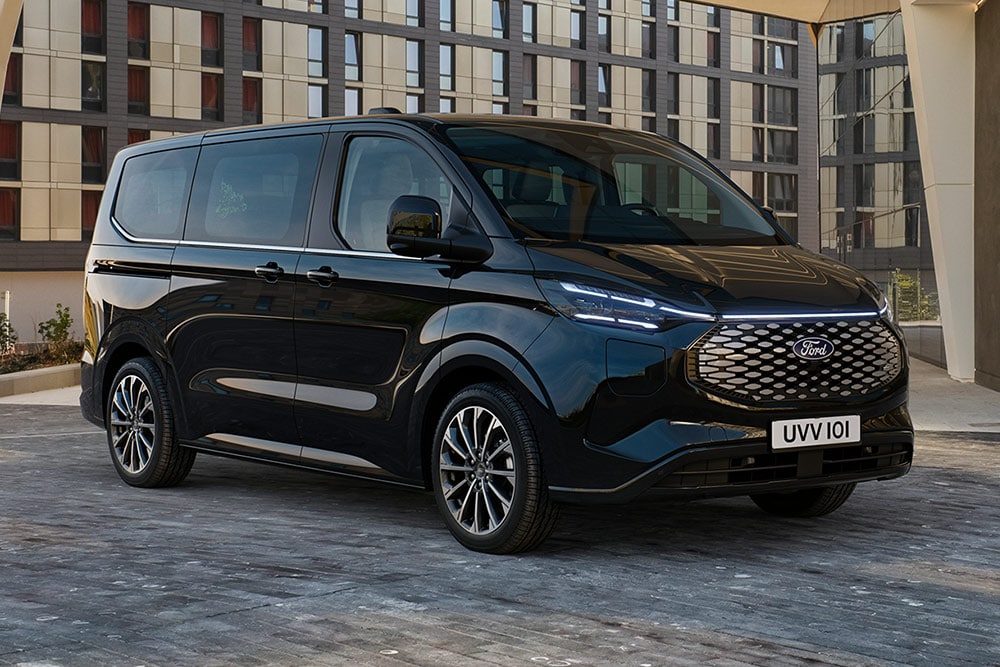 Ford Pro Transit noir garé devant un bâtiment moderne.