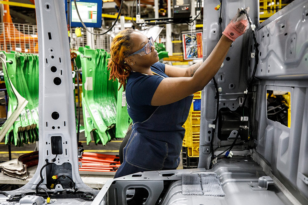 Mécanicien Ford travaillant sur une camionnette dans un garage.