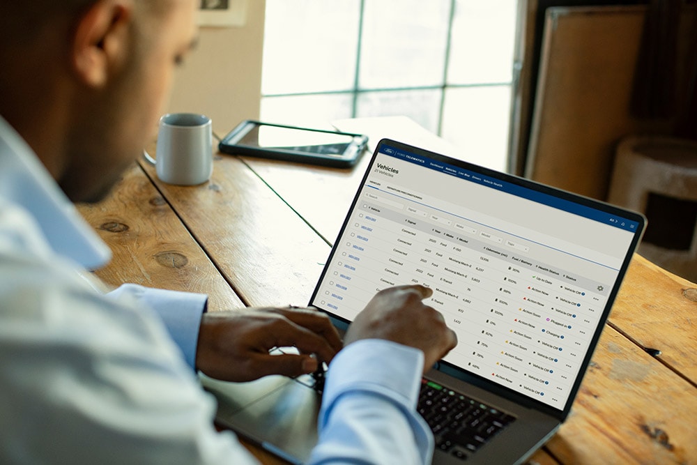 Un gestionnaire de flotte Ford Pro consulte les données du véhicule sur son ordinateur portable.