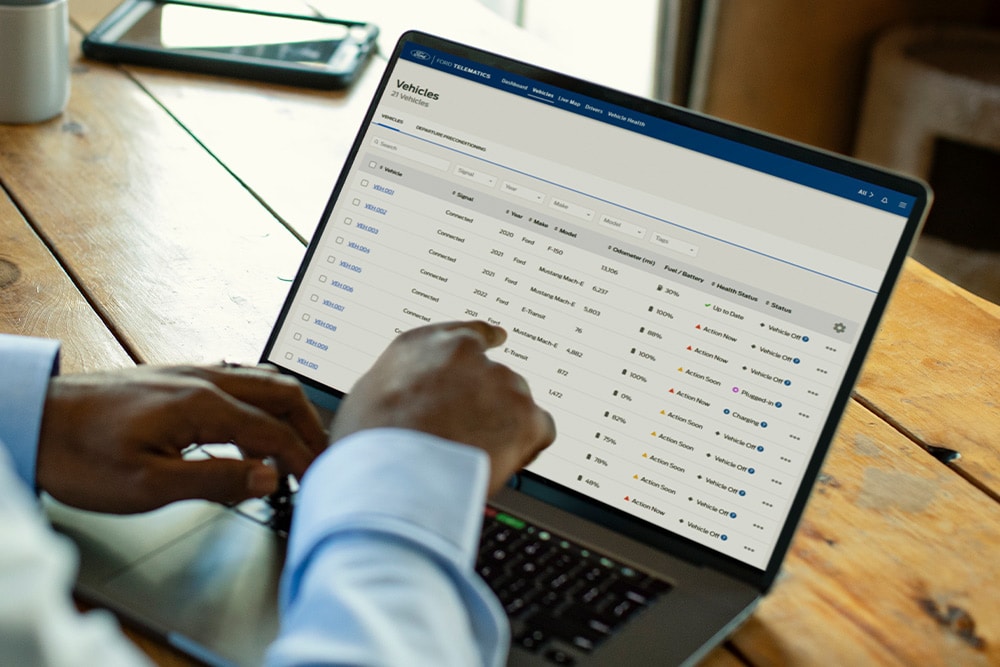 Un gestionnaire de flotte Ford Pro consulte les données du véhicule sur son ordinateur portable.