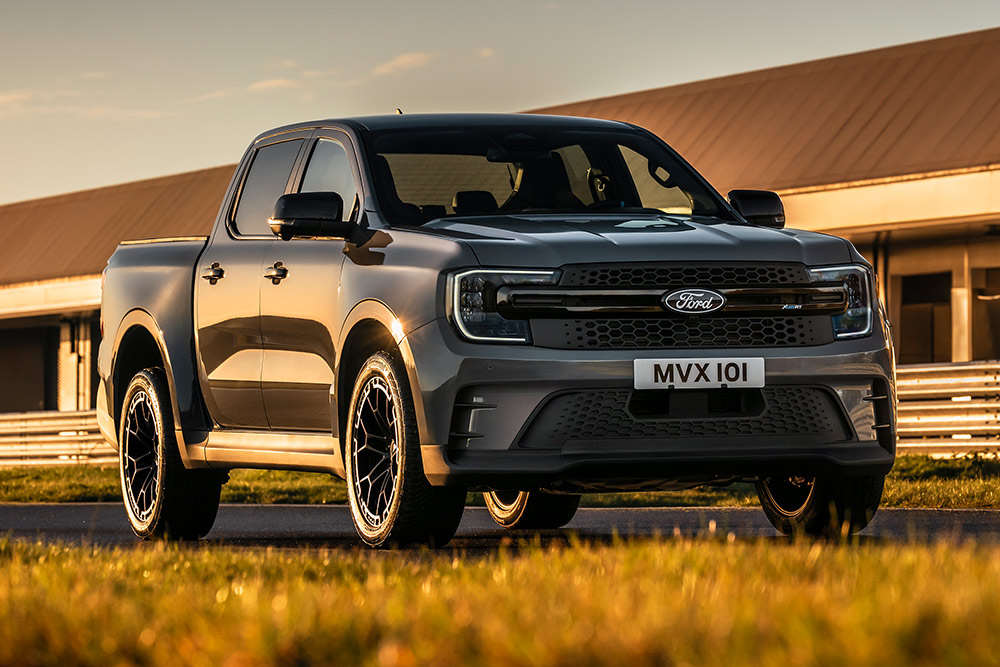 Ford Pro Ranger Plug-in Hybrid argenté garé devant un bâtiment industriel.