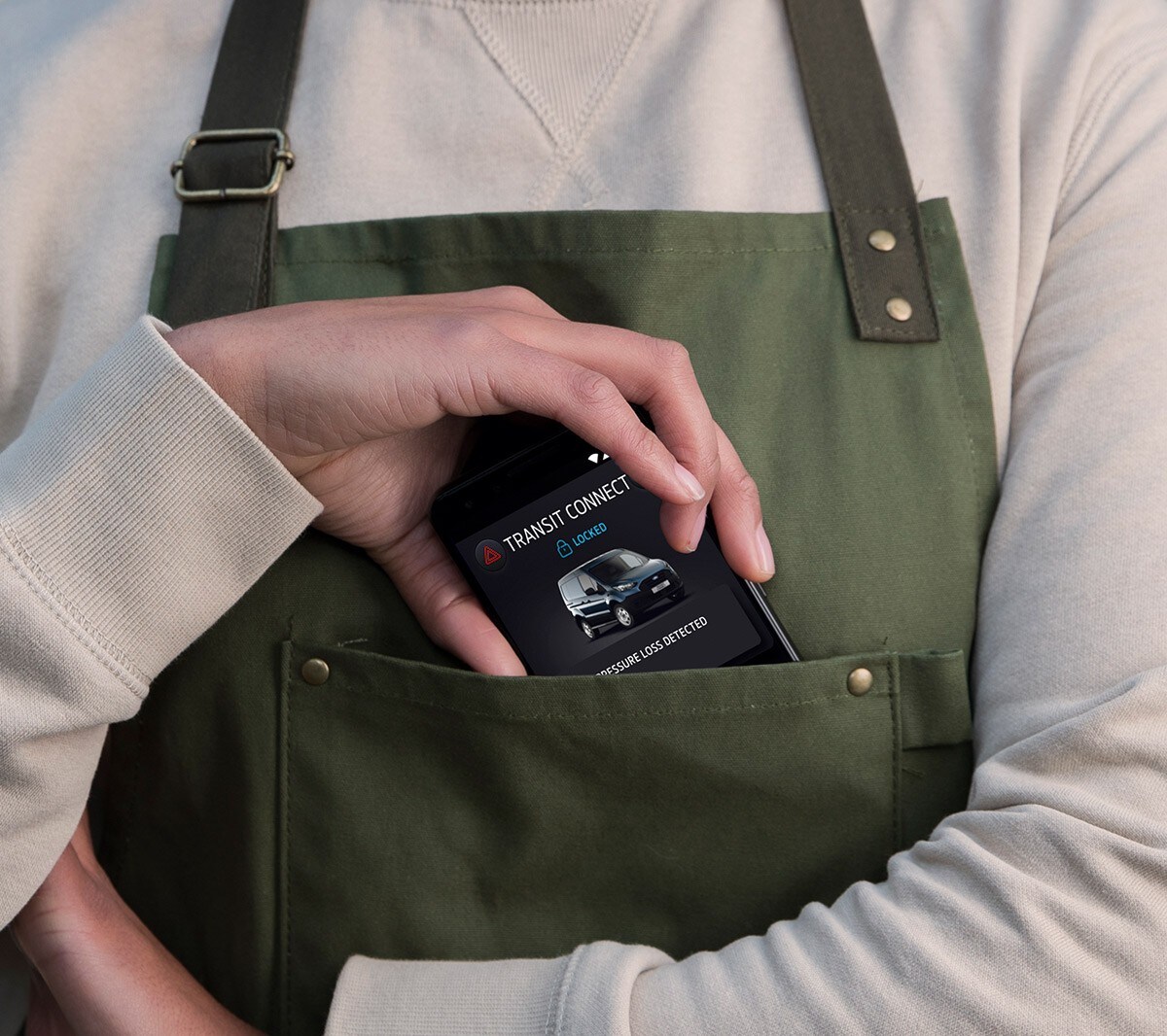 Gros plan sur une main mettant un téléphone portable dans une poche.