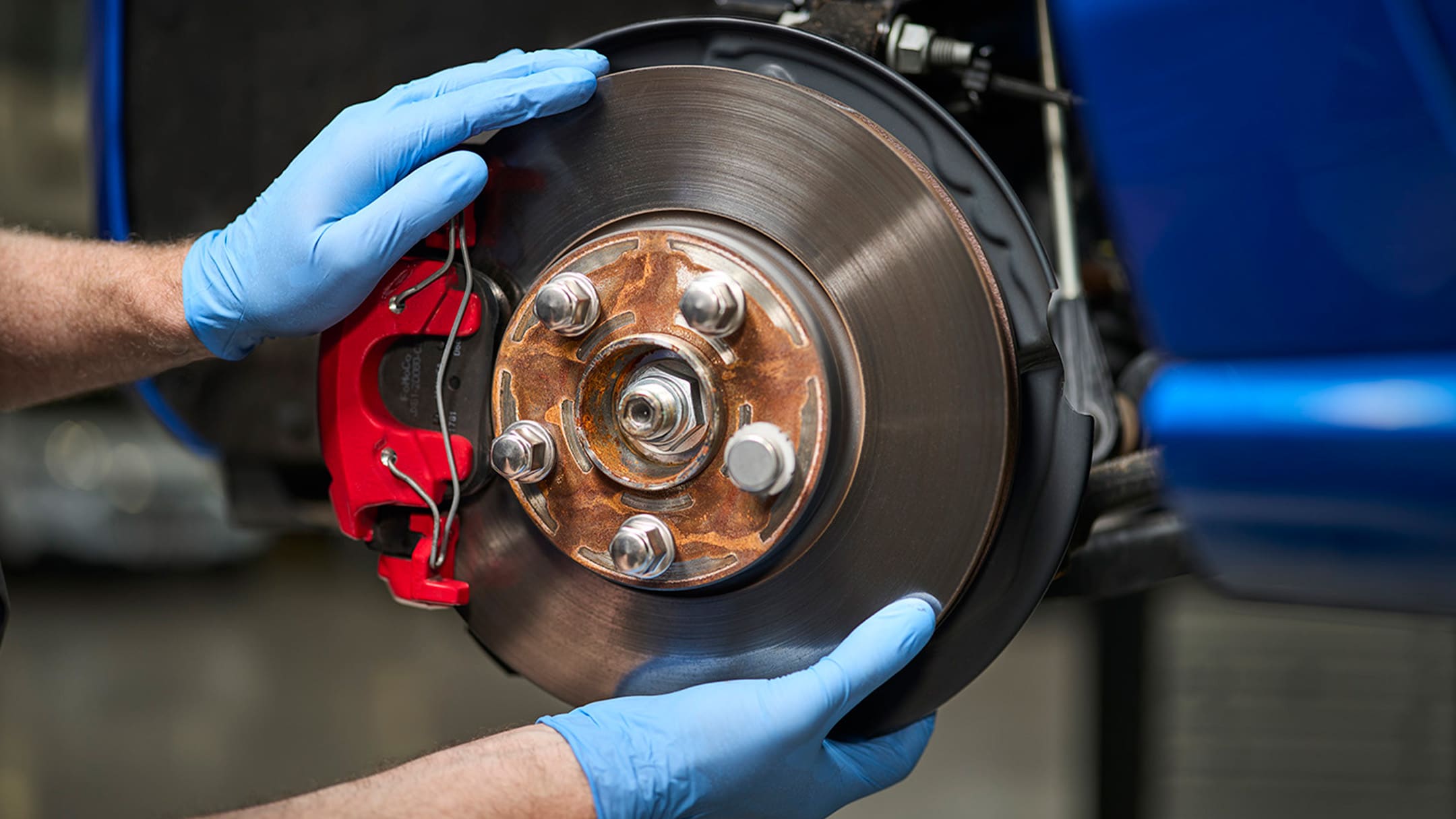 Un mécanicien tient une pièce d’origine Ford lors d’un entretien ou d’une réparation.