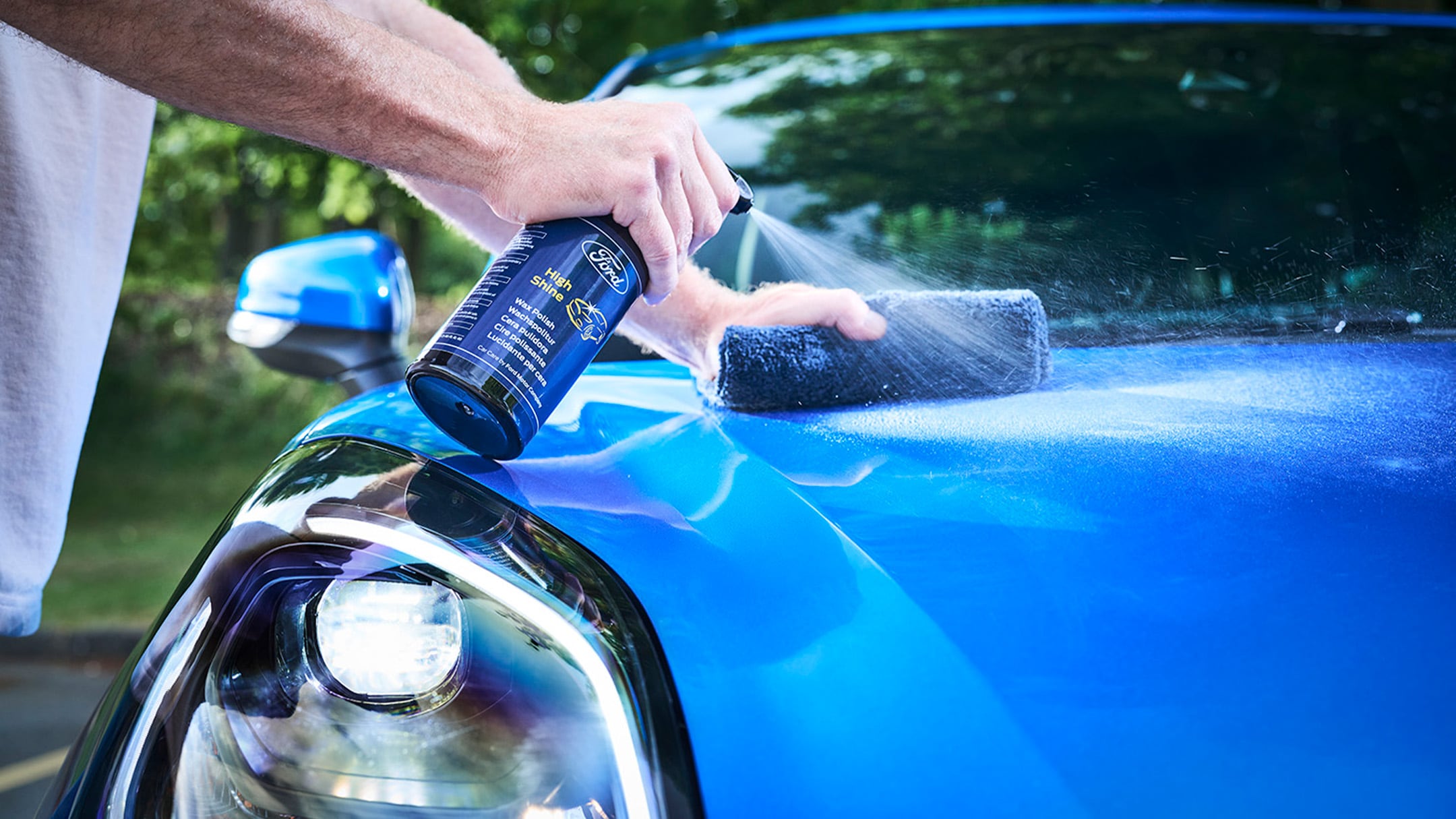 Un mécanicien dans un centre de service Ford tenant une pièce détachée d'origine Ford emballée.​