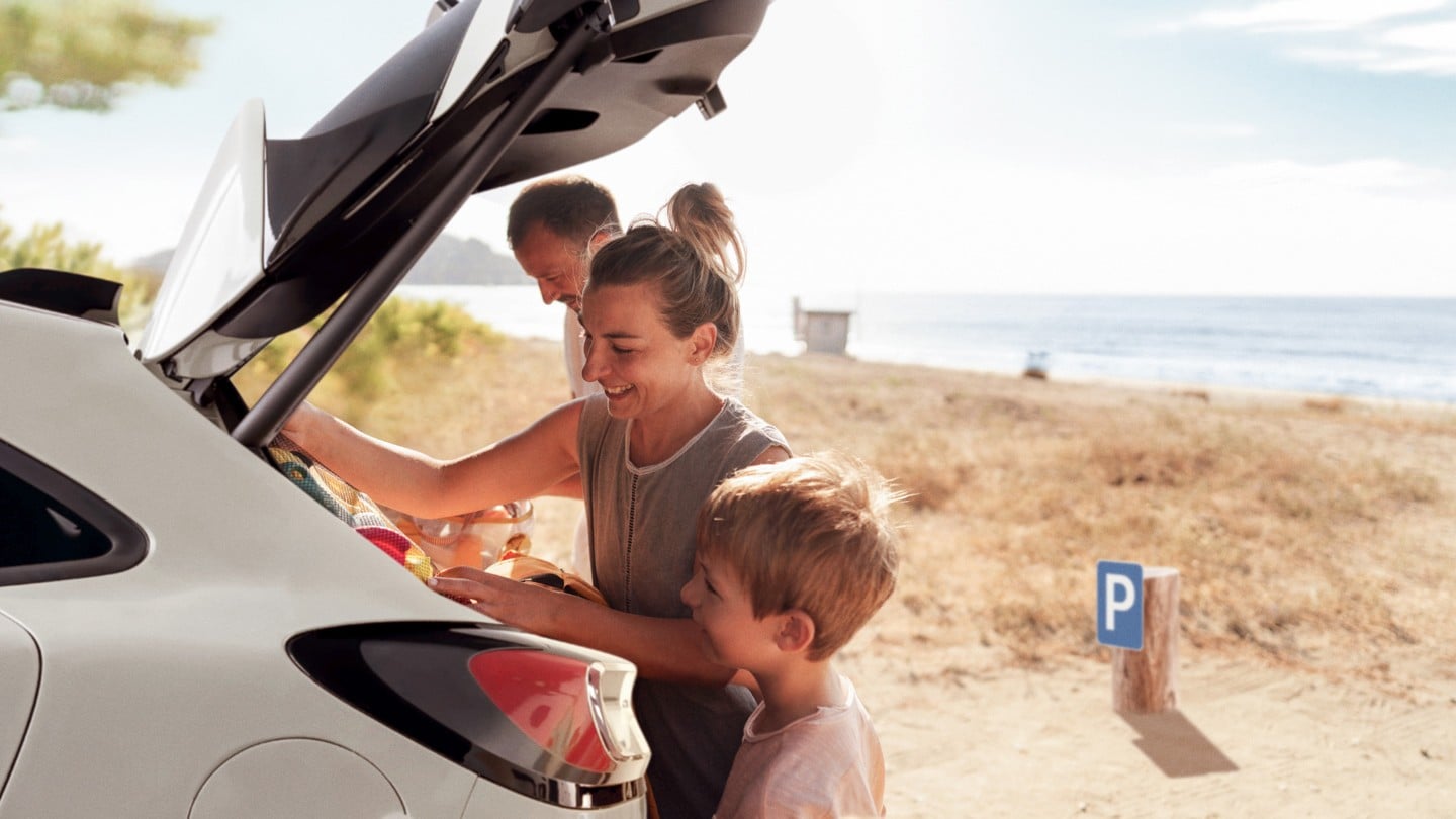 Une famille à la plage charge ses affaires dans le coffre d’un véhicule Ford.