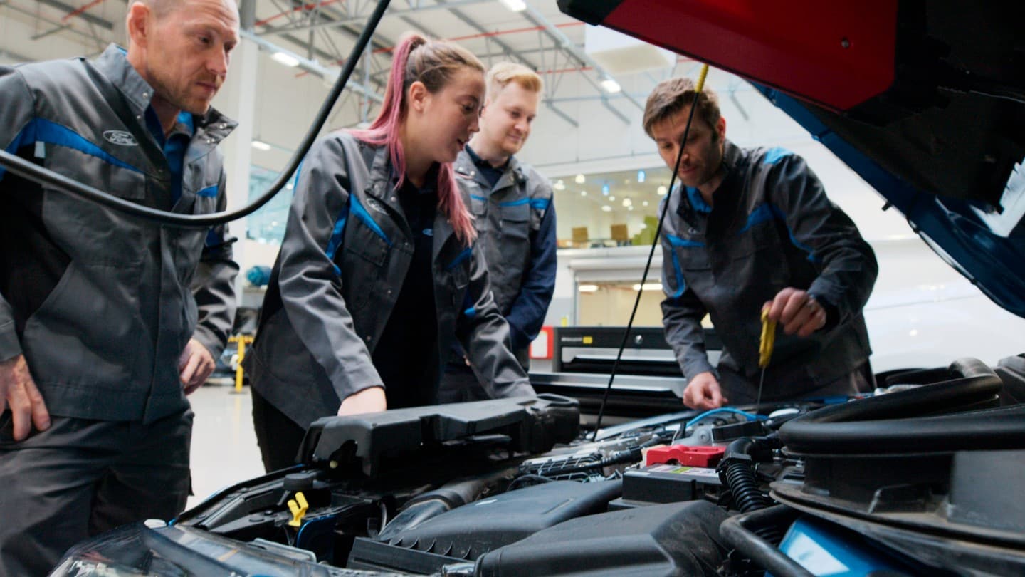 Des chargés de clientèle Ford travaillant sur une voiture