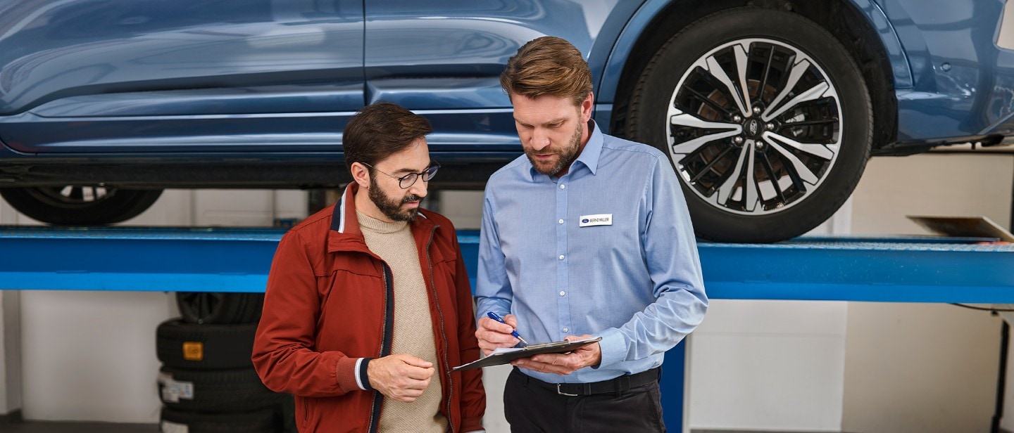 Ford service repair engineer, showing client a report